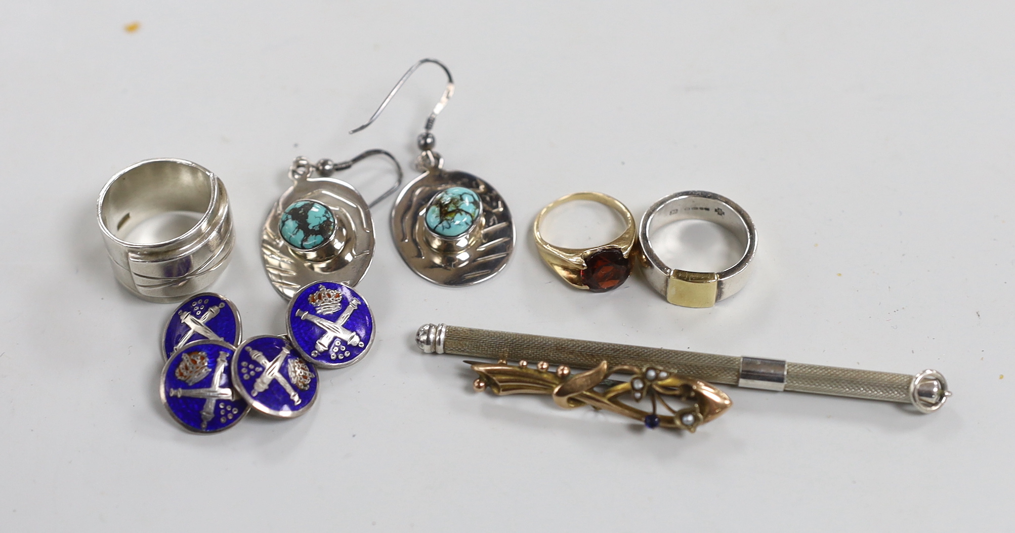 Mixed jewellery including a pair of silver and turquoise earrings by Pruden & Smith, two other silver rings, a 9ct and garnet set ring, a silver twizzle stick, a 9ct and gem set brooch and a pair of white metal and ename